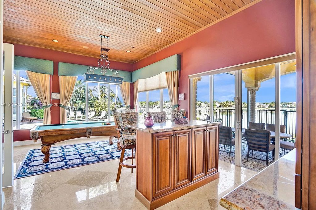 3308 Islewood Avenue, Weston, Florida is located in the prestigious gated community of Windmill Reserve, and it offers luxurious living on a grand scale. Situated on a premium lake lot with a lushly landscaped yard, this home in Weston features a gas-heated pool/spa, covered summer kitchen, Chicago brick patio, and roll-down shades, making it perfect for entertaining guests or enjoying time with family.