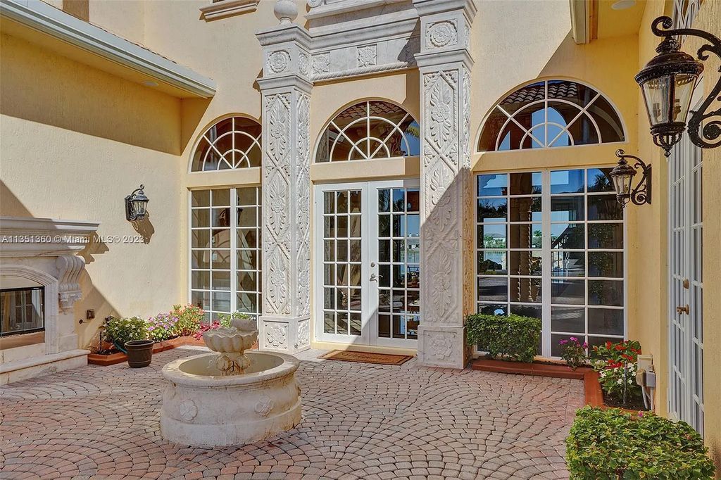 3308 Islewood Avenue, Weston, Florida is located in the prestigious gated community of Windmill Reserve, and it offers luxurious living on a grand scale. Situated on a premium lake lot with a lushly landscaped yard, this home in Weston features a gas-heated pool/spa, covered summer kitchen, Chicago brick patio, and roll-down shades, making it perfect for entertaining guests or enjoying time with family.