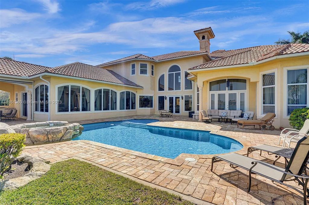 3308 Islewood Avenue, Weston, Florida is located in the prestigious gated community of Windmill Reserve, and it offers luxurious living on a grand scale. Situated on a premium lake lot with a lushly landscaped yard, this home in Weston features a gas-heated pool/spa, covered summer kitchen, Chicago brick patio, and roll-down shades, making it perfect for entertaining guests or enjoying time with family.