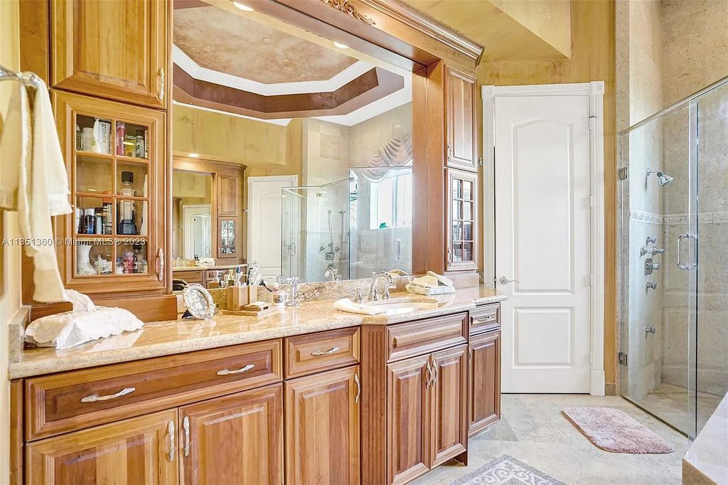 3308 Islewood Avenue, Weston, Florida is located in the prestigious gated community of Windmill Reserve, and it offers luxurious living on a grand scale. Situated on a premium lake lot with a lushly landscaped yard, this home in Weston features a gas-heated pool/spa, covered summer kitchen, Chicago brick patio, and roll-down shades, making it perfect for entertaining guests or enjoying time with family.