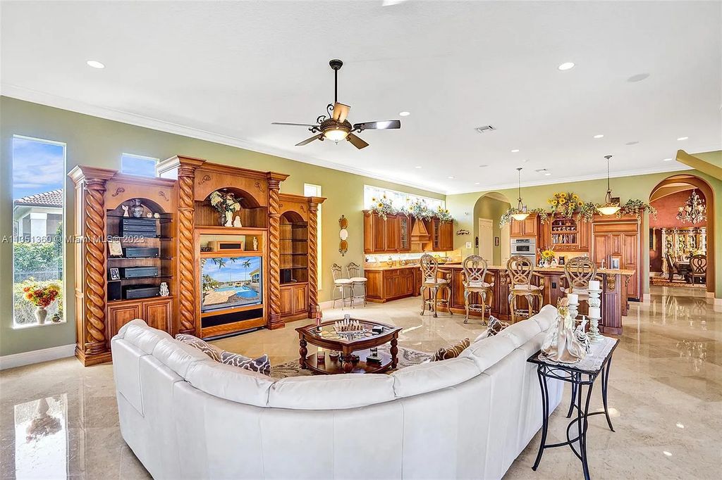 3308 Islewood Avenue, Weston, Florida is located in the prestigious gated community of Windmill Reserve, and it offers luxurious living on a grand scale. Situated on a premium lake lot with a lushly landscaped yard, this home in Weston features a gas-heated pool/spa, covered summer kitchen, Chicago brick patio, and roll-down shades, making it perfect for entertaining guests or enjoying time with family.