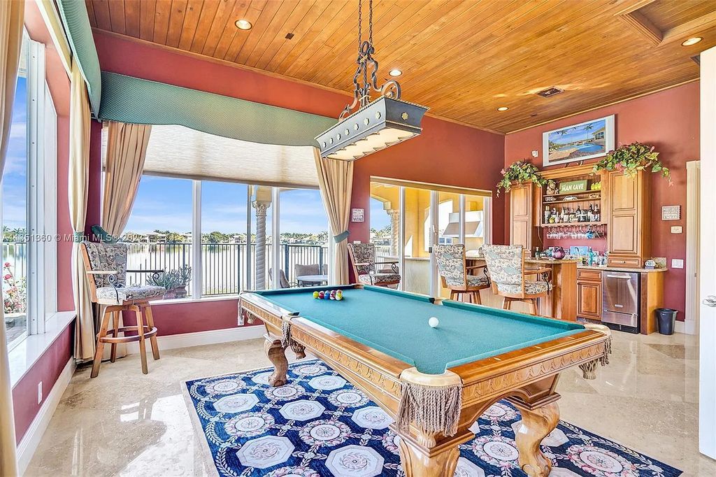3308 Islewood Avenue, Weston, Florida is located in the prestigious gated community of Windmill Reserve, and it offers luxurious living on a grand scale. Situated on a premium lake lot with a lushly landscaped yard, this home in Weston features a gas-heated pool/spa, covered summer kitchen, Chicago brick patio, and roll-down shades, making it perfect for entertaining guests or enjoying time with family.