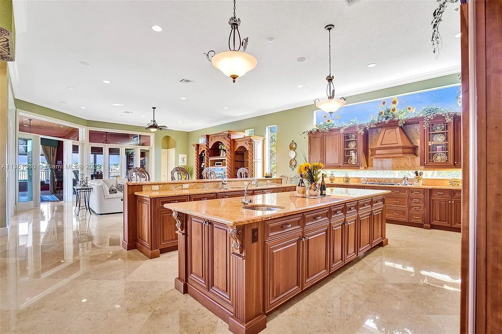 3308 Islewood Avenue, Weston, Florida is located in the prestigious gated community of Windmill Reserve, and it offers luxurious living on a grand scale. Situated on a premium lake lot with a lushly landscaped yard, this home in Weston features a gas-heated pool/spa, covered summer kitchen, Chicago brick patio, and roll-down shades, making it perfect for entertaining guests or enjoying time with family.