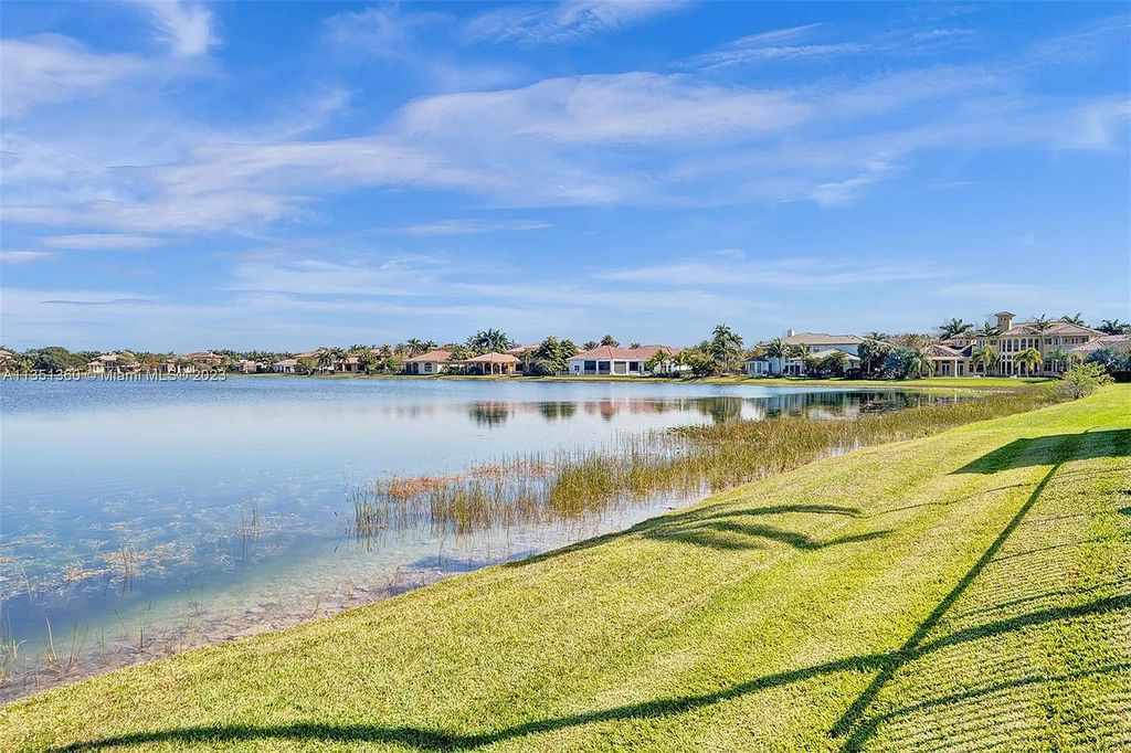 3308 Islewood Avenue, Weston, Florida is located in the prestigious gated community of Windmill Reserve, and it offers luxurious living on a grand scale. Situated on a premium lake lot with a lushly landscaped yard, this home in Weston features a gas-heated pool/spa, covered summer kitchen, Chicago brick patio, and roll-down shades, making it perfect for entertaining guests or enjoying time with family.