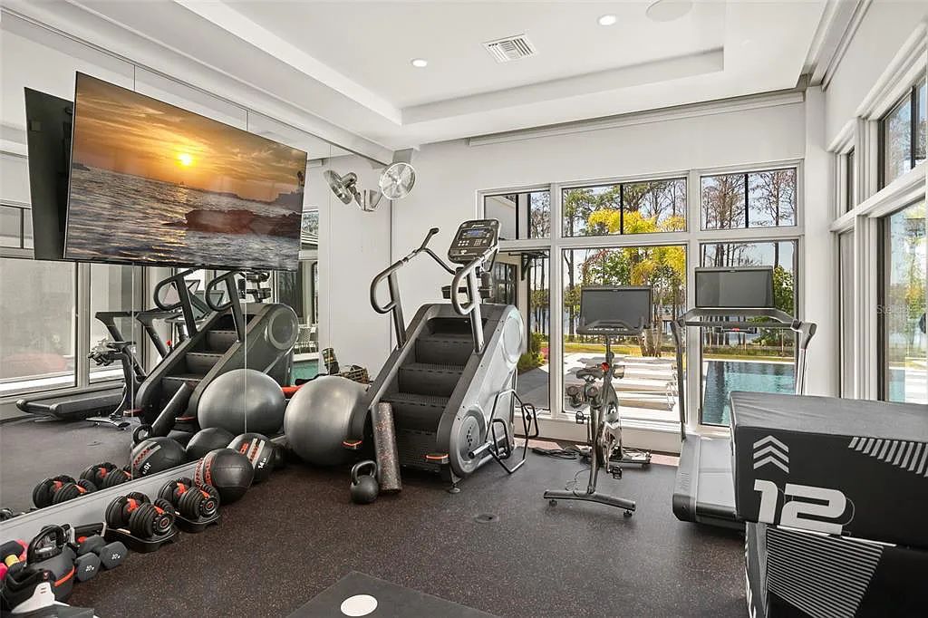This luxurious lakefront mansion at 9306 Blanche Cove Drive in Windermere, Florida, is a custom-crafted masterpiece built for the ultimate sports enthusiast. The 5-bedroom, 8-bath home spans 14,856 square feet and includes a 6,060 square foot air-conditioned full-sized basketball court, a theater, an exercise room with sauna, and a two-story master closet.