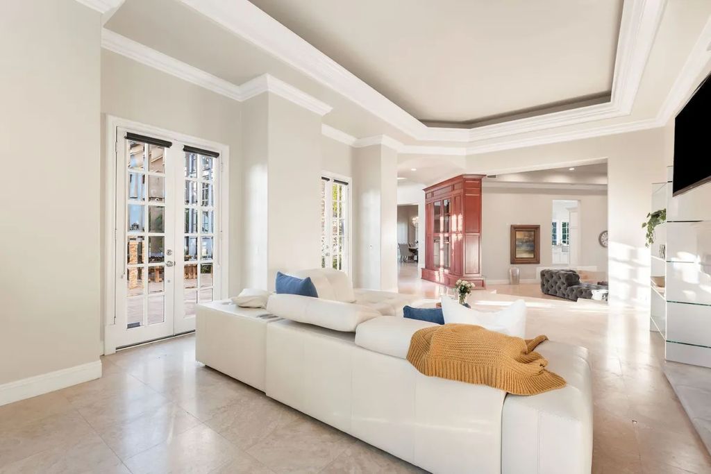 This exquisite estate offers breathtaking 360-degree views of the ocean sunsets, city lights, and Santa Monica mountains skyline, visible from its three stunning balconies. With over 9,300 square feet of space, this luxurious property boasts five bedrooms, seven bathrooms, three living rooms, formal and informal dining areas, and five beautiful fireplaces. The grand entrance through double doors leads to a dramatic 2-story foyer with 30-foot windows that flood the space with natural light, and limestone floors create an elegant touch.
