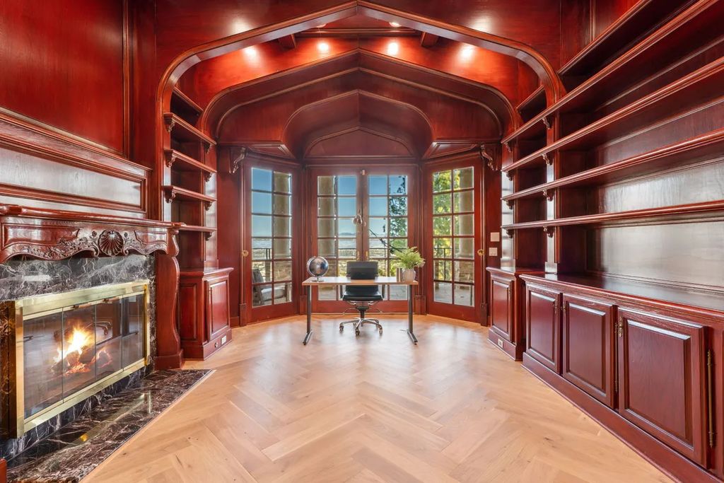 This exquisite estate offers breathtaking 360-degree views of the ocean sunsets, city lights, and Santa Monica mountains skyline, visible from its three stunning balconies. With over 9,300 square feet of space, this luxurious property boasts five bedrooms, seven bathrooms, three living rooms, formal and informal dining areas, and five beautiful fireplaces. The grand entrance through double doors leads to a dramatic 2-story foyer with 30-foot windows that flood the space with natural light, and limestone floors create an elegant touch.