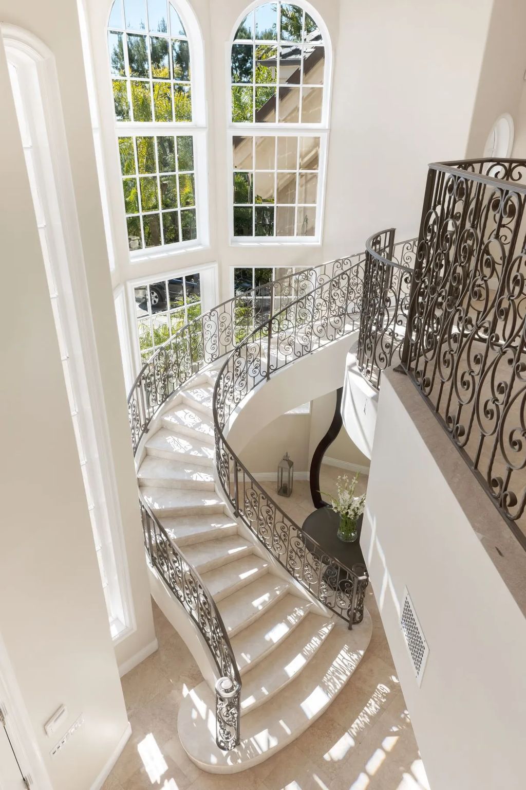 This exquisite estate offers breathtaking 360-degree views of the ocean sunsets, city lights, and Santa Monica mountains skyline, visible from its three stunning balconies. With over 9,300 square feet of space, this luxurious property boasts five bedrooms, seven bathrooms, three living rooms, formal and informal dining areas, and five beautiful fireplaces. The grand entrance through double doors leads to a dramatic 2-story foyer with 30-foot windows that flood the space with natural light, and limestone floors create an elegant touch.