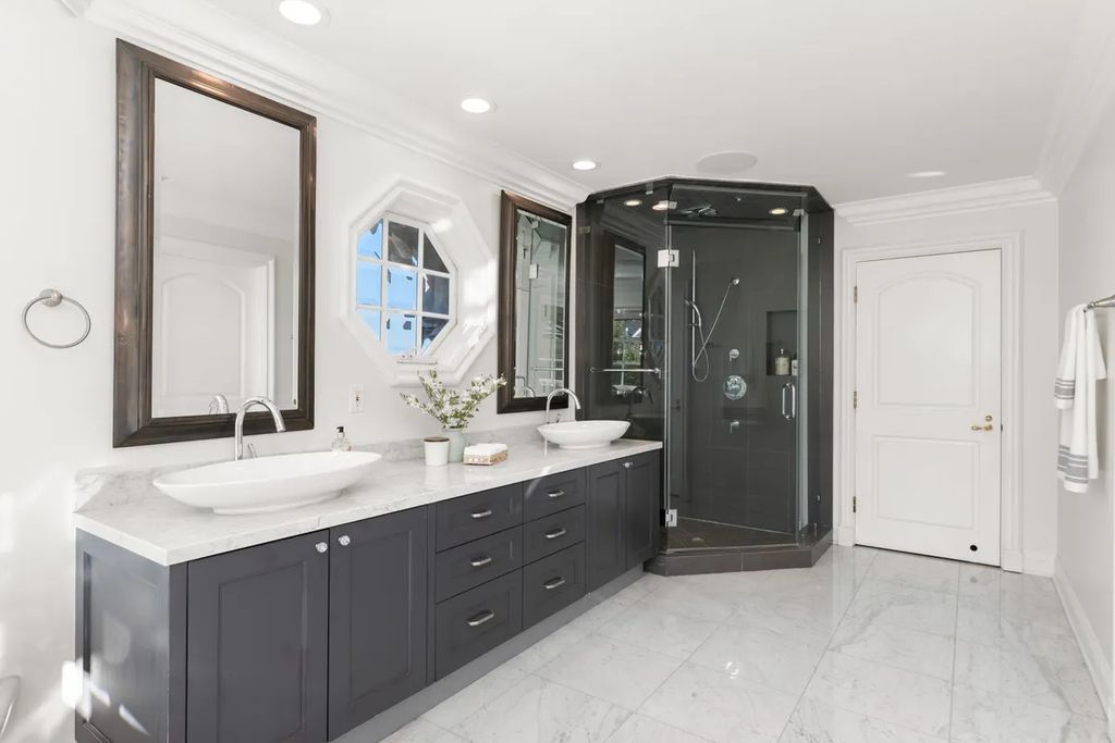 This exquisite estate offers breathtaking 360-degree views of the ocean sunsets, city lights, and Santa Monica mountains skyline, visible from its three stunning balconies. With over 9,300 square feet of space, this luxurious property boasts five bedrooms, seven bathrooms, three living rooms, formal and informal dining areas, and five beautiful fireplaces. The grand entrance through double doors leads to a dramatic 2-story foyer with 30-foot windows that flood the space with natural light, and limestone floors create an elegant touch.