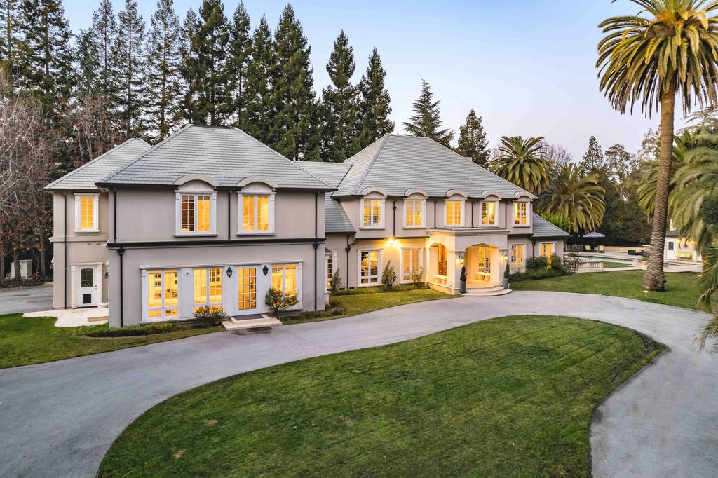 18 Cowell Lane Home in Atherton, California. Indulge in the perfect blend of privacy and luxury within the serene surroundings of this magnificent Atherton estate. Nestled on over an acre of meticulously maintained grounds, this exceptional home exudes style and elegance at every turn, boasting over 6,800 square feet of living space. Impeccable craftsmanship is showcased throughout, with exquisite details including stone, marble, and mahogany finishes. 