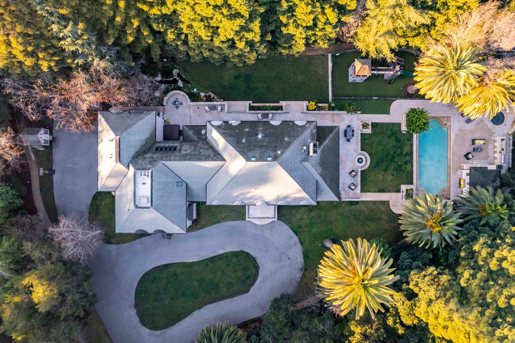 18 Cowell Lane Home in Atherton, California. Indulge in the perfect blend of privacy and luxury within the serene surroundings of this magnificent Atherton estate. Nestled on over an acre of meticulously maintained grounds, this exceptional home exudes style and elegance at every turn, boasting over 6,800 square feet of living space. Impeccable craftsmanship is showcased throughout, with exquisite details including stone, marble, and mahogany finishes. 