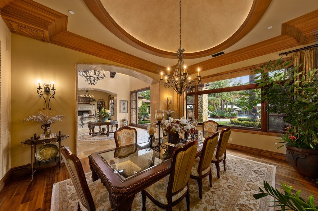 Indulge in the lavishness of a sprawling Mediterranean estate located on 4.71 acres in the sought-after Rancho Santa Fe. This private gated property boasts a grand Tuscan villa with a circular drive featuring a serene fountain and four separate stone and vine-covered structures surrounded by lush greenery.
