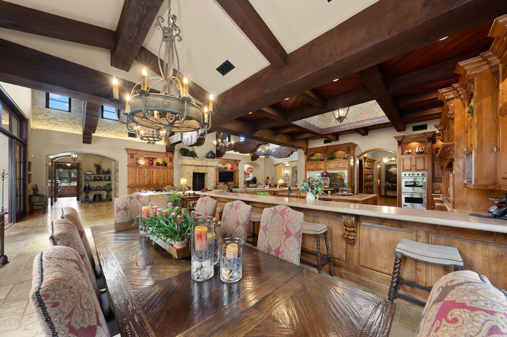 Indulge in the lavishness of a sprawling Mediterranean estate located on 4.71 acres in the sought-after Rancho Santa Fe. This private gated property boasts a grand Tuscan villa with a circular drive featuring a serene fountain and four separate stone and vine-covered structures surrounded by lush greenery.