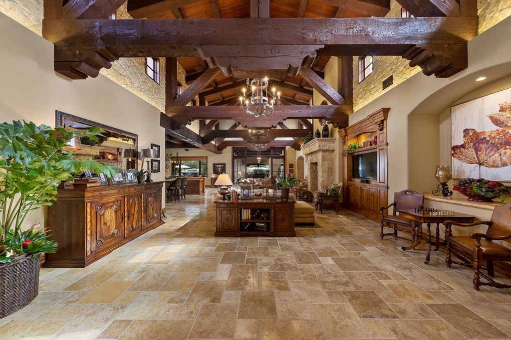 Indulge in the lavishness of a sprawling Mediterranean estate located on 4.71 acres in the sought-after Rancho Santa Fe. This private gated property boasts a grand Tuscan villa with a circular drive featuring a serene fountain and four separate stone and vine-covered structures surrounded by lush greenery.
