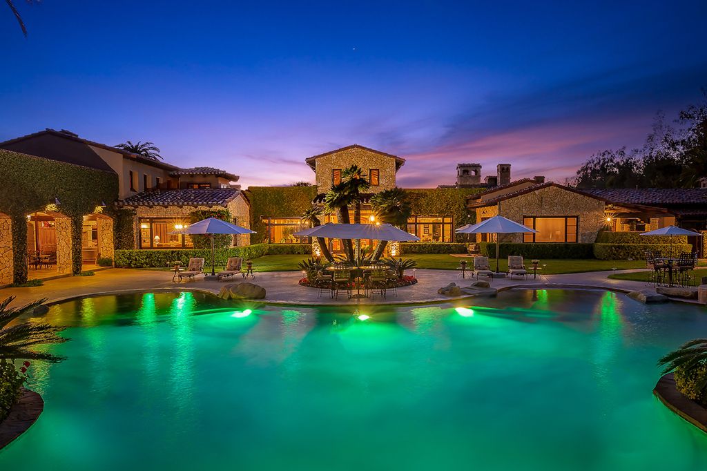 Indulge in the lavishness of a sprawling Mediterranean estate located on 4.71 acres in the sought-after Rancho Santa Fe. This private gated property boasts a grand Tuscan villa with a circular drive featuring a serene fountain and four separate stone and vine-covered structures surrounded by lush greenery.