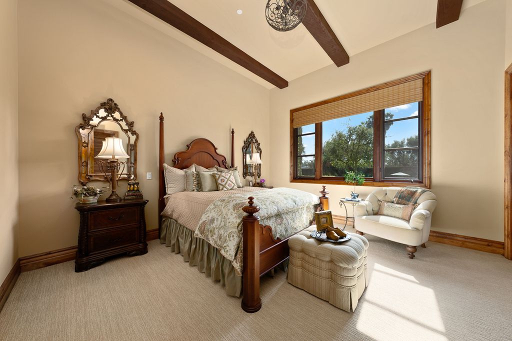 Indulge in the lavishness of a sprawling Mediterranean estate located on 4.71 acres in the sought-after Rancho Santa Fe. This private gated property boasts a grand Tuscan villa with a circular drive featuring a serene fountain and four separate stone and vine-covered structures surrounded by lush greenery.