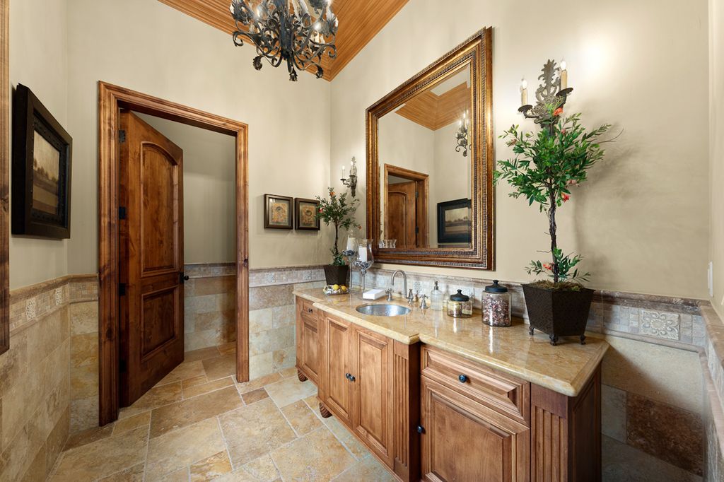 Indulge in the lavishness of a sprawling Mediterranean estate located on 4.71 acres in the sought-after Rancho Santa Fe. This private gated property boasts a grand Tuscan villa with a circular drive featuring a serene fountain and four separate stone and vine-covered structures surrounded by lush greenery.
