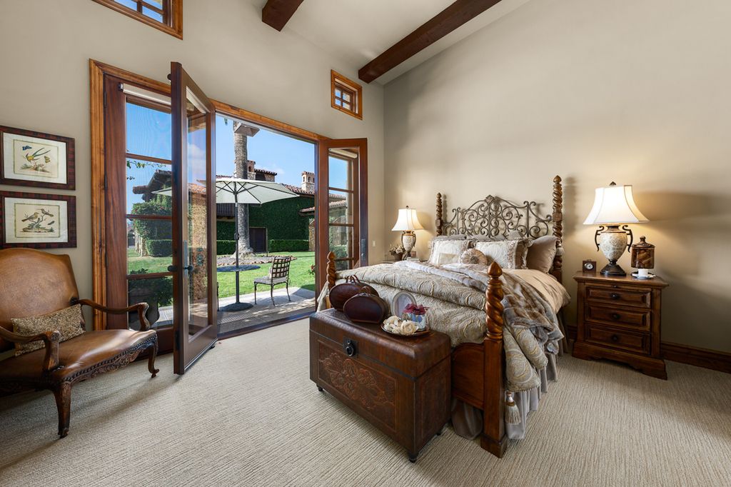 Indulge in the lavishness of a sprawling Mediterranean estate located on 4.71 acres in the sought-after Rancho Santa Fe. This private gated property boasts a grand Tuscan villa with a circular drive featuring a serene fountain and four separate stone and vine-covered structures surrounded by lush greenery.