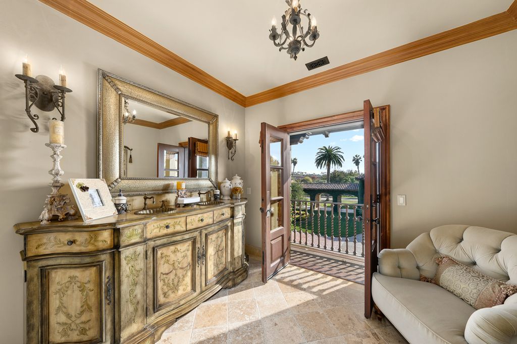 Indulge in the lavishness of a sprawling Mediterranean estate located on 4.71 acres in the sought-after Rancho Santa Fe. This private gated property boasts a grand Tuscan villa with a circular drive featuring a serene fountain and four separate stone and vine-covered structures surrounded by lush greenery.