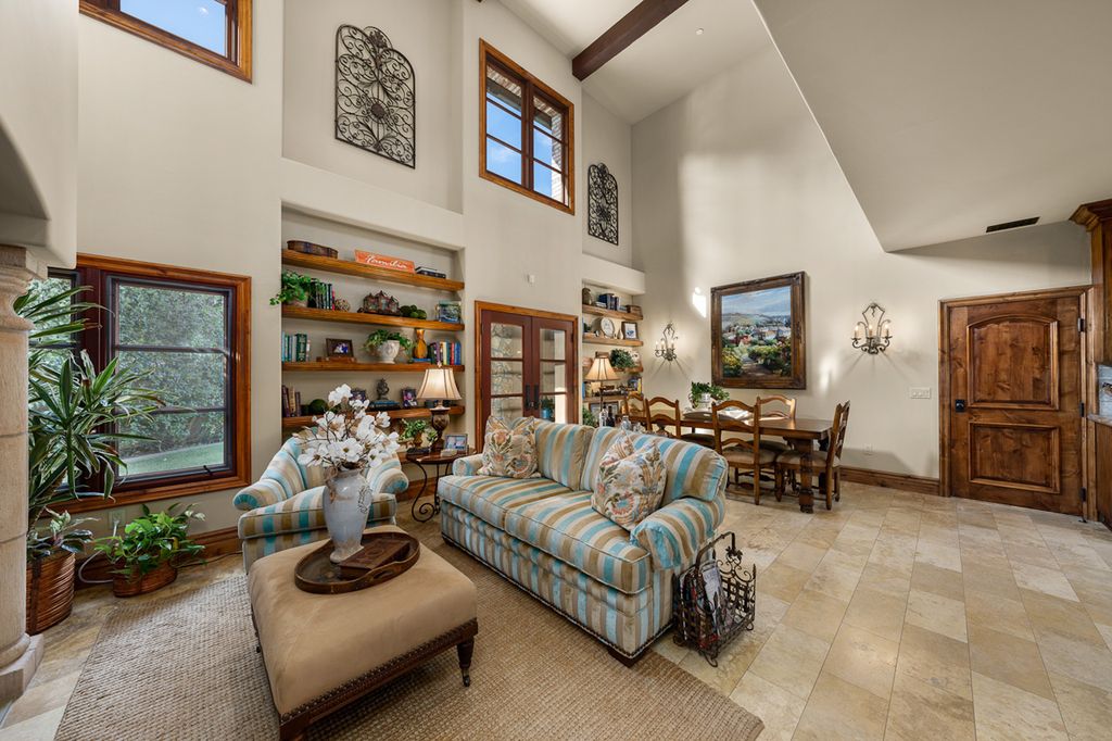 Indulge in the lavishness of a sprawling Mediterranean estate located on 4.71 acres in the sought-after Rancho Santa Fe. This private gated property boasts a grand Tuscan villa with a circular drive featuring a serene fountain and four separate stone and vine-covered structures surrounded by lush greenery.