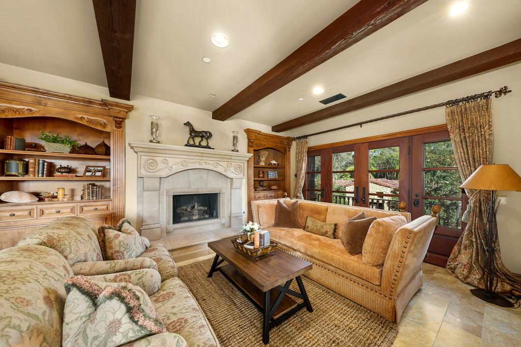 Indulge in the lavishness of a sprawling Mediterranean estate located on 4.71 acres in the sought-after Rancho Santa Fe. This private gated property boasts a grand Tuscan villa with a circular drive featuring a serene fountain and four separate stone and vine-covered structures surrounded by lush greenery.