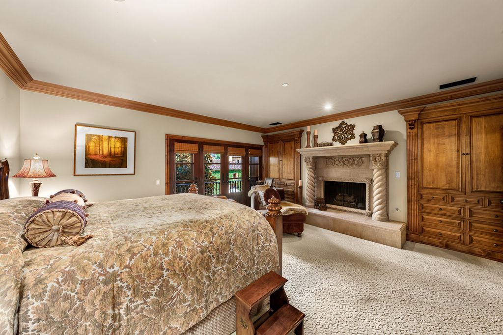 Indulge in the lavishness of a sprawling Mediterranean estate located on 4.71 acres in the sought-after Rancho Santa Fe. This private gated property boasts a grand Tuscan villa with a circular drive featuring a serene fountain and four separate stone and vine-covered structures surrounded by lush greenery.