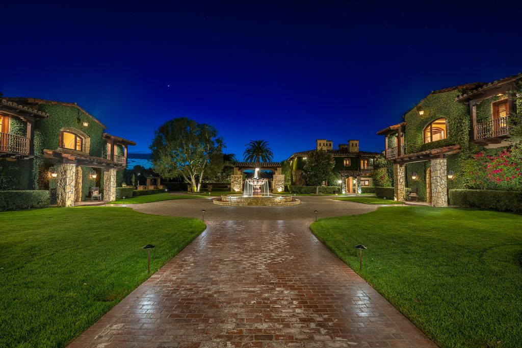 Indulge in the lavishness of a sprawling Mediterranean estate located on 4.71 acres in the sought-after Rancho Santa Fe. This private gated property boasts a grand Tuscan villa with a circular drive featuring a serene fountain and four separate stone and vine-covered structures surrounded by lush greenery.