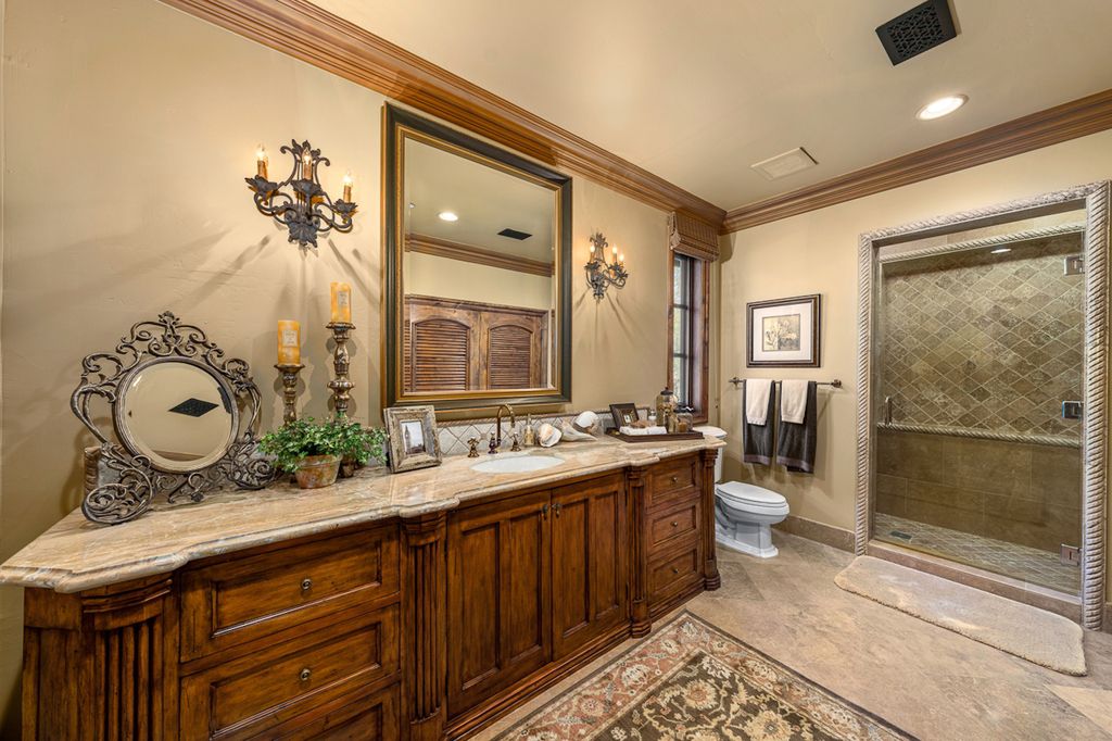Indulge in the lavishness of a sprawling Mediterranean estate located on 4.71 acres in the sought-after Rancho Santa Fe. This private gated property boasts a grand Tuscan villa with a circular drive featuring a serene fountain and four separate stone and vine-covered structures surrounded by lush greenery.