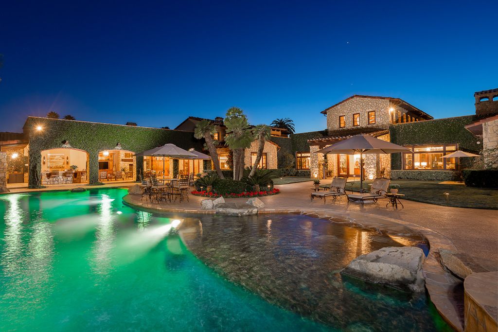 Indulge in the lavishness of a sprawling Mediterranean estate located on 4.71 acres in the sought-after Rancho Santa Fe. This private gated property boasts a grand Tuscan villa with a circular drive featuring a serene fountain and four separate stone and vine-covered structures surrounded by lush greenery.