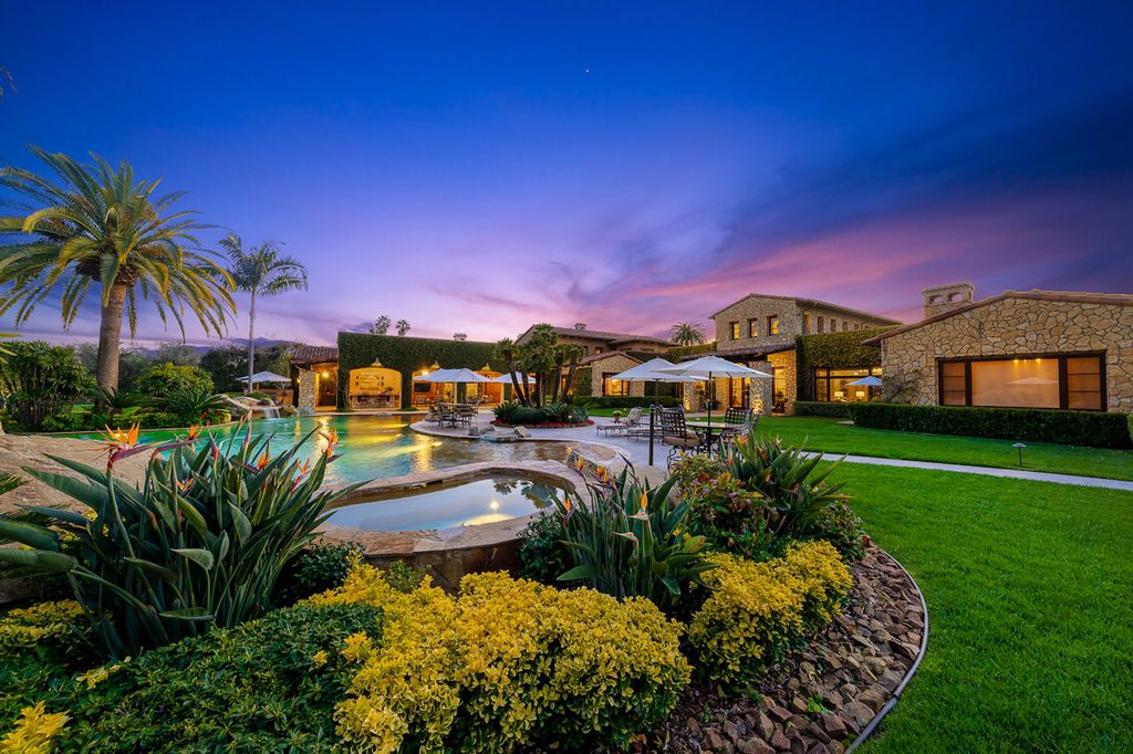 Indulge in the lavishness of a sprawling Mediterranean estate located on 4.71 acres in the sought-after Rancho Santa Fe. This private gated property boasts a grand Tuscan villa with a circular drive featuring a serene fountain and four separate stone and vine-covered structures surrounded by lush greenery.