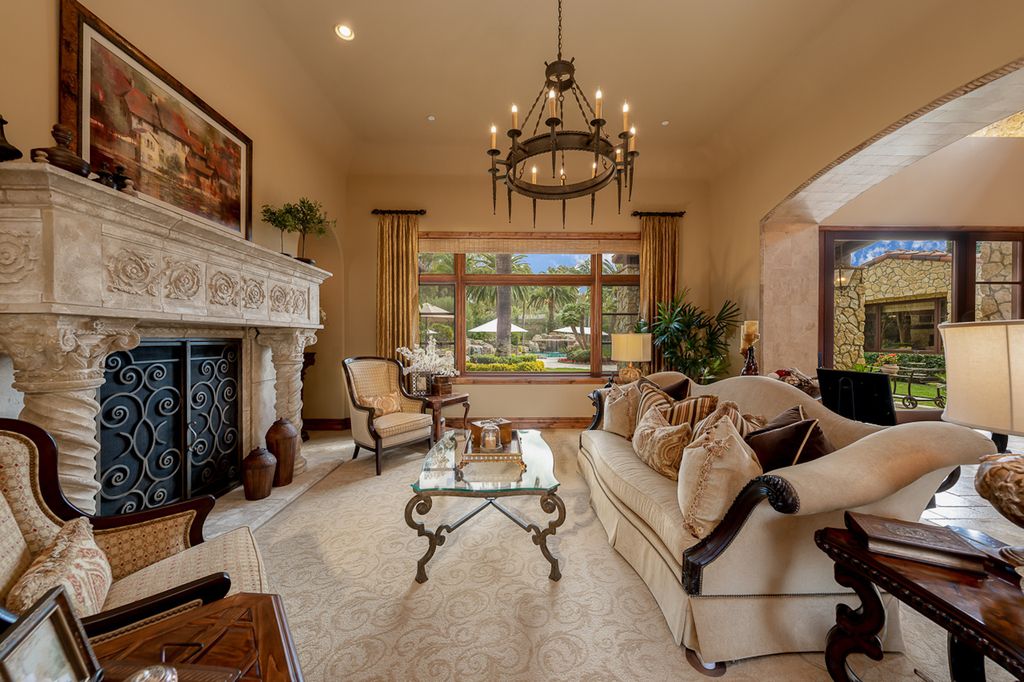 Indulge in the lavishness of a sprawling Mediterranean estate located on 4.71 acres in the sought-after Rancho Santa Fe. This private gated property boasts a grand Tuscan villa with a circular drive featuring a serene fountain and four separate stone and vine-covered structures surrounded by lush greenery.