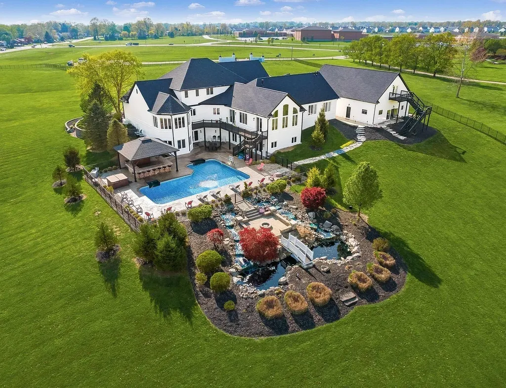 12100 Toll Gate Court NW Home in Pickerington, Ohio. Discover an entertainer's dream with this extraordinary 19.66 acre estate boasting over 16,000 square feet of living space. Immerse yourself in serene surroundings, including a creek, pond, and lush wooded areas, all complemented by a 6-car garage. Indulge in the opulent charm of the 6-bedroom, 6.5-bathroom main house, along with a separate 3-bedroom, 2-bathroom guest house. 