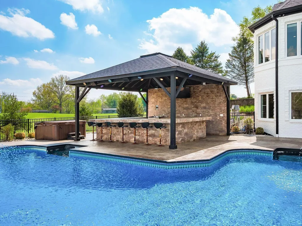 12100 Toll Gate Court NW Home in Pickerington, Ohio. Discover an entertainer's dream with this extraordinary 19.66 acre estate boasting over 16,000 square feet of living space. Immerse yourself in serene surroundings, including a creek, pond, and lush wooded areas, all complemented by a 6-car garage. Indulge in the opulent charm of the 6-bedroom, 6.5-bathroom main house, along with a separate 3-bedroom, 2-bathroom guest house. 