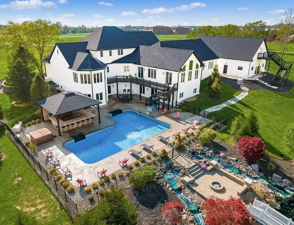 12100 Toll Gate Court NW Home in Pickerington, Ohio. Discover an entertainer's dream with this extraordinary 19.66 acre estate boasting over 16,000 square feet of living space. Immerse yourself in serene surroundings, including a creek, pond, and lush wooded areas, all complemented by a 6-car garage. Indulge in the opulent charm of the 6-bedroom, 6.5-bathroom main house, along with a separate 3-bedroom, 2-bathroom guest house. 