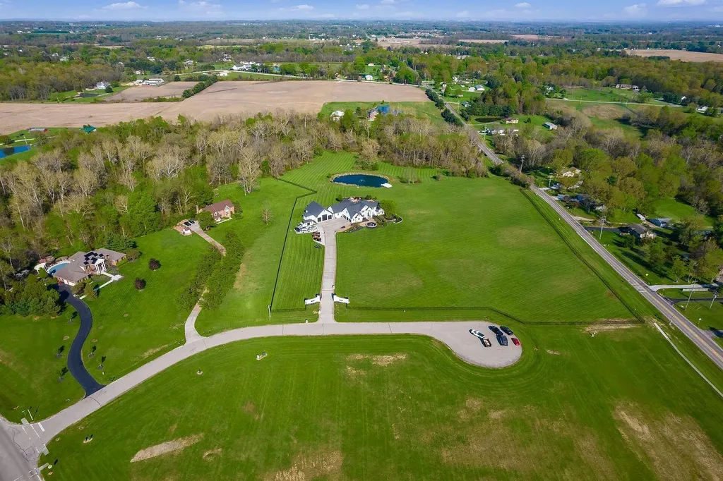 12100 Toll Gate Court NW Home in Pickerington, Ohio. Discover an entertainer's dream with this extraordinary 19.66 acre estate boasting over 16,000 square feet of living space. Immerse yourself in serene surroundings, including a creek, pond, and lush wooded areas, all complemented by a 6-car garage. Indulge in the opulent charm of the 6-bedroom, 6.5-bathroom main house, along with a separate 3-bedroom, 2-bathroom guest house. 