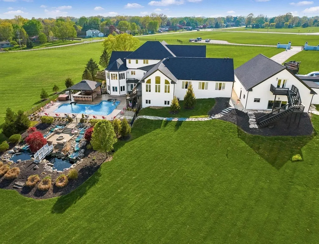12100 Toll Gate Court NW Home in Pickerington, Ohio. Discover an entertainer's dream with this extraordinary 19.66 acre estate boasting over 16,000 square feet of living space. Immerse yourself in serene surroundings, including a creek, pond, and lush wooded areas, all complemented by a 6-car garage. Indulge in the opulent charm of the 6-bedroom, 6.5-bathroom main house, along with a separate 3-bedroom, 2-bathroom guest house. 