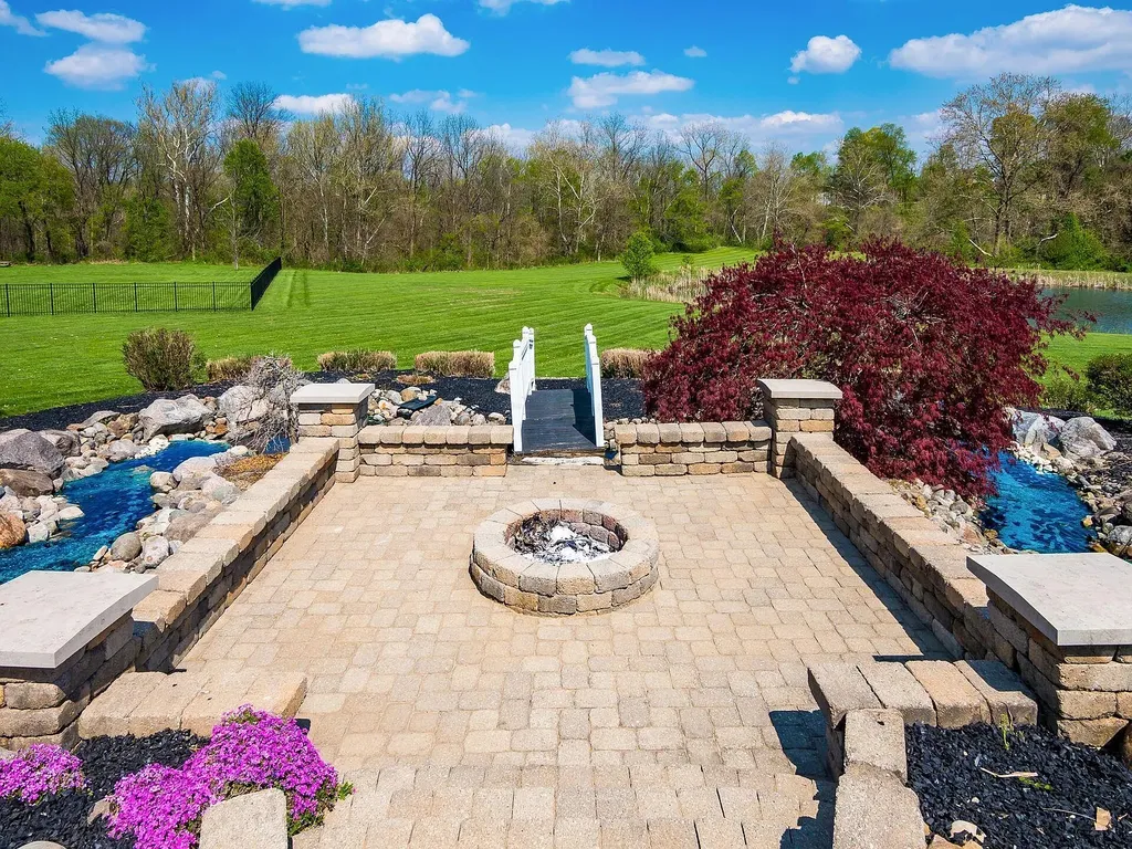 12100 Toll Gate Court NW Home in Pickerington, Ohio. Discover an entertainer's dream with this extraordinary 19.66 acre estate boasting over 16,000 square feet of living space. Immerse yourself in serene surroundings, including a creek, pond, and lush wooded areas, all complemented by a 6-car garage. Indulge in the opulent charm of the 6-bedroom, 6.5-bathroom main house, along with a separate 3-bedroom, 2-bathroom guest house. 