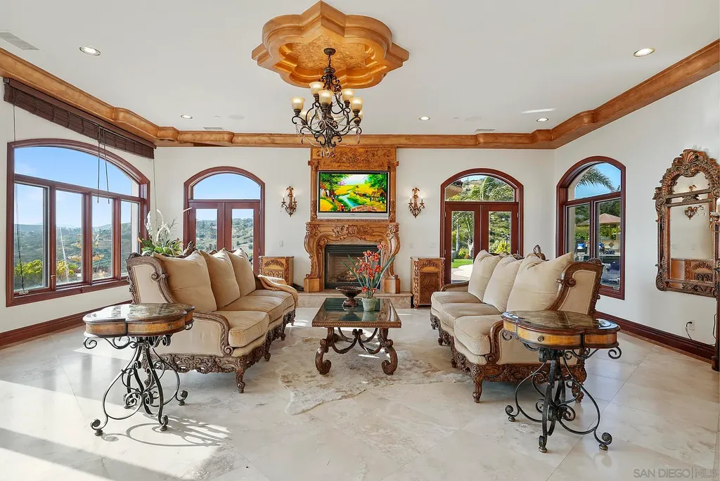 Elevated on a hill in Blossom Valley, this exquisite home offers a living experience that is truly unmatched. Nestled within a gated estate, the property expands across six acres of meticulously landscaped grounds, showcasing natural rock formations and a vibrant variety of palm trees, succulents, and blooming flowers. Embracing eco-friendly features such as a ground-water well and solar panels, this residence seamlessly blends sustainability with luxurious living. 15987 Broad Oaks Road Home in El Cajon, California.
