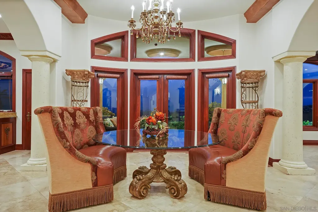 Elevated on a hill in Blossom Valley, this exquisite home offers a living experience that is truly unmatched. Nestled within a gated estate, the property expands across six acres of meticulously landscaped grounds, showcasing natural rock formations and a vibrant variety of palm trees, succulents, and blooming flowers. Embracing eco-friendly features such as a ground-water well and solar panels, this residence seamlessly blends sustainability with luxurious living. 15987 Broad Oaks Road Home in El Cajon, California.