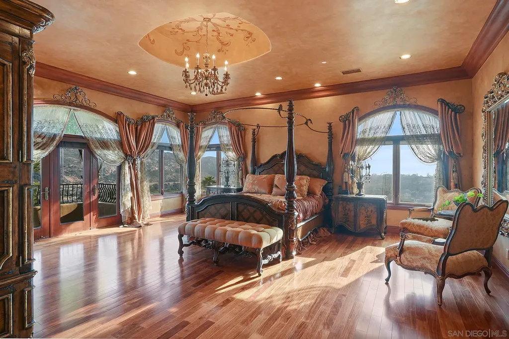 Elevated on a hill in Blossom Valley, this exquisite home offers a living experience that is truly unmatched. Nestled within a gated estate, the property expands across six acres of meticulously landscaped grounds, showcasing natural rock formations and a vibrant variety of palm trees, succulents, and blooming flowers. Embracing eco-friendly features such as a ground-water well and solar panels, this residence seamlessly blends sustainability with luxurious living. 15987 Broad Oaks Road Home in El Cajon, California.