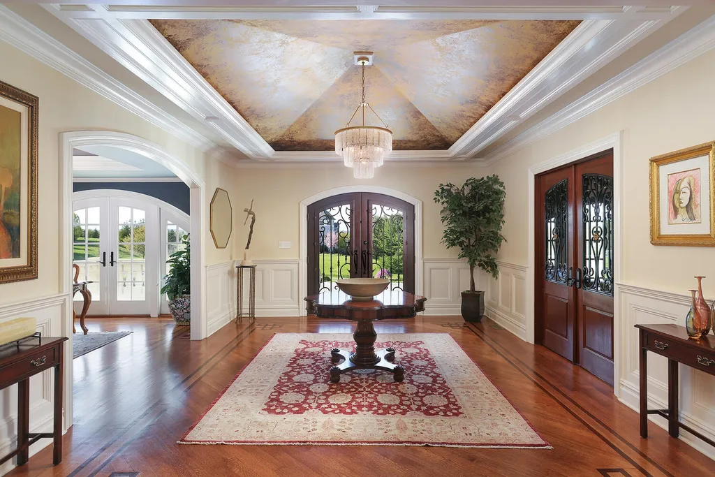 16 Tall Timber Lane Home in Bernards Township, New Jersey. Discover an extraordinary French Chateau-inspired property boasting nearly 12,000 sq ft of living space. This remarkable estate offers unparalleled luxury, featuring special amenities such as an elevator for easy accessibility, a first-floor guest suite, and radiant heated floors throughout, including the basement and garage. Indulge in the opulent 4,200 sq ft walk-out lower level, featuring high ceilings, a movie theater, expansive bar, gym, full spa bathroom with sauna, workshop, second laundry room, multiple entertainment areas, and potential for a sixth bedroom ensuite.