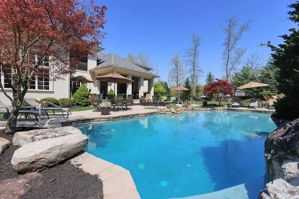 16 Tall Timber Lane Home in Bernards Township, New Jersey. Discover an extraordinary French Chateau-inspired property boasting nearly 12,000 sq ft of living space. This remarkable estate offers unparalleled luxury, featuring special amenities such as an elevator for easy accessibility, a first-floor guest suite, and radiant heated floors throughout, including the basement and garage. Indulge in the opulent 4,200 sq ft walk-out lower level, featuring high ceilings, a movie theater, expansive bar, gym, full spa bathroom with sauna, workshop, second laundry room, multiple entertainment areas, and potential for a sixth bedroom ensuite.
