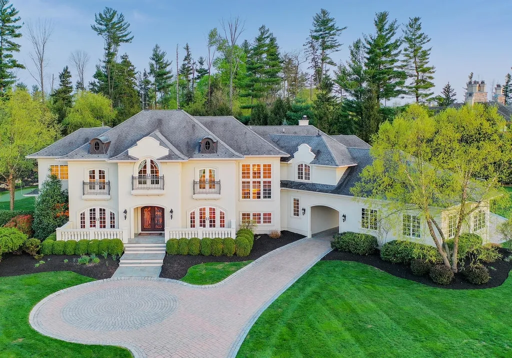16 Tall Timber Lane Home in Bernards Township, New Jersey. Discover an extraordinary French Chateau-inspired property boasting nearly 12,000 sq ft of living space. This remarkable estate offers unparalleled luxury, featuring special amenities such as an elevator for easy accessibility, a first-floor guest suite, and radiant heated floors throughout, including the basement and garage. Indulge in the opulent 4,200 sq ft walk-out lower level, featuring high ceilings, a movie theater, expansive bar, gym, full spa bathroom with sauna, workshop, second laundry room, multiple entertainment areas, and potential for a sixth bedroom ensuite.