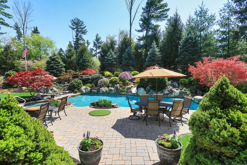 16 Tall Timber Lane Home in Bernards Township, New Jersey. Discover an extraordinary French Chateau-inspired property boasting nearly 12,000 sq ft of living space. This remarkable estate offers unparalleled luxury, featuring special amenities such as an elevator for easy accessibility, a first-floor guest suite, and radiant heated floors throughout, including the basement and garage. Indulge in the opulent 4,200 sq ft walk-out lower level, featuring high ceilings, a movie theater, expansive bar, gym, full spa bathroom with sauna, workshop, second laundry room, multiple entertainment areas, and potential for a sixth bedroom ensuite.