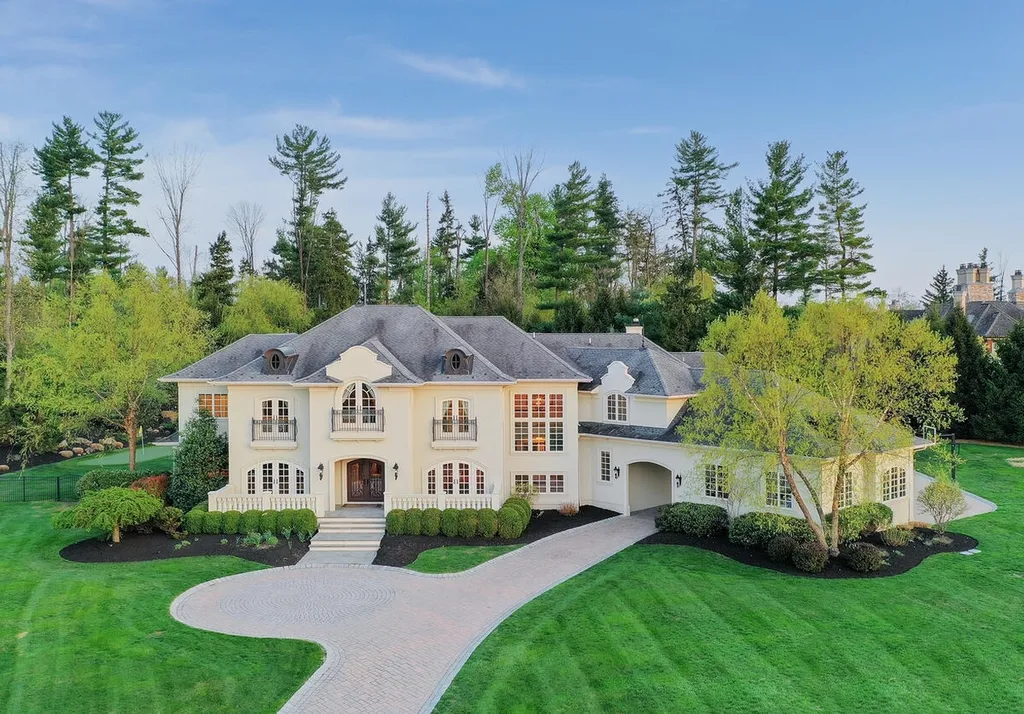 16 Tall Timber Lane Home in Bernards Township, New Jersey. Discover an extraordinary French Chateau-inspired property boasting nearly 12,000 sq ft of living space. This remarkable estate offers unparalleled luxury, featuring special amenities such as an elevator for easy accessibility, a first-floor guest suite, and radiant heated floors throughout, including the basement and garage. Indulge in the opulent 4,200 sq ft walk-out lower level, featuring high ceilings, a movie theater, expansive bar, gym, full spa bathroom with sauna, workshop, second laundry room, multiple entertainment areas, and potential for a sixth bedroom ensuite.