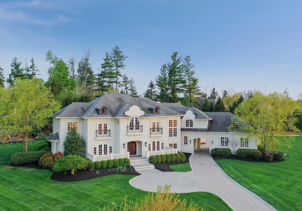 16 Tall Timber Lane Home in Bernards Township, New Jersey. Discover an extraordinary French Chateau-inspired property boasting nearly 12,000 sq ft of living space. This remarkable estate offers unparalleled luxury, featuring special amenities such as an elevator for easy accessibility, a first-floor guest suite, and radiant heated floors throughout, including the basement and garage. Indulge in the opulent 4,200 sq ft walk-out lower level, featuring high ceilings, a movie theater, expansive bar, gym, full spa bathroom with sauna, workshop, second laundry room, multiple entertainment areas, and potential for a sixth bedroom ensuite.