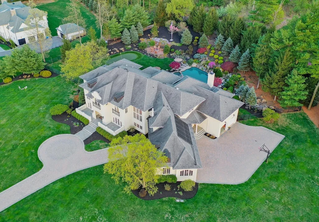 16 Tall Timber Lane Home in Bernards Township, New Jersey. Discover an extraordinary French Chateau-inspired property boasting nearly 12,000 sq ft of living space. This remarkable estate offers unparalleled luxury, featuring special amenities such as an elevator for easy accessibility, a first-floor guest suite, and radiant heated floors throughout, including the basement and garage. Indulge in the opulent 4,200 sq ft walk-out lower level, featuring high ceilings, a movie theater, expansive bar, gym, full spa bathroom with sauna, workshop, second laundry room, multiple entertainment areas, and potential for a sixth bedroom ensuite.