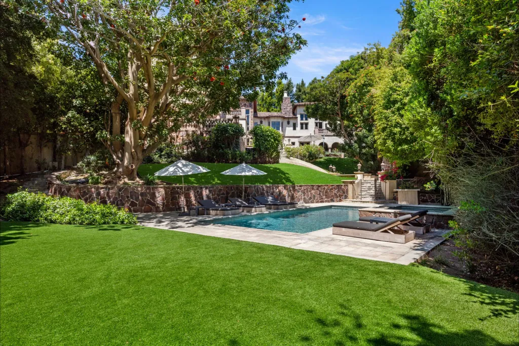 206 N Carolwood Drive Home in Los Angeles, California. Experience the epitome of luxurious living in this contemporary Tuscany-style estate nestled on the prestigious Carolwood Drive in prime Holmby Hills. Beyond the private gated entrance, this magnificent 10-bedroom, 10-bathroom residence awaits, surrounded by towering trees and lushly landscaped verdant grounds. Built with natural woods and imported stone, the home's romantic exterior seamlessly blends with the tranquil beauty of its surroundings.