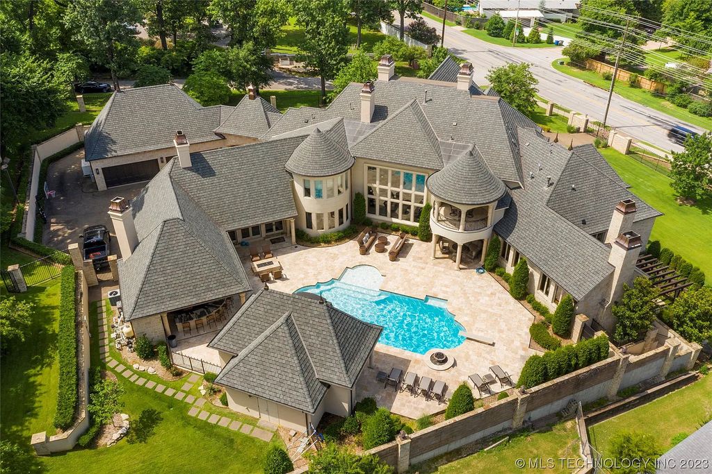2411 E 34th Street Home in Tulsa, Oklahoma. Experience the epitome of luxury in this one-of-a-kind, majestic midtown mansion. Built in 2010, this stunning residence showcases high ceilings and bright, open rooms that overlook an incredible backyard oasis. Ideal for entertaining, the home features multiple game rooms, a theater, two gyms, a billiards room, and a cigar lounge with ventilation to the outside. Indulge in the 1,000-bottle wine room, relax by the spacious pool and spa, and enjoy outdoor dining with the convenient outdoor kitchen and covered living area.