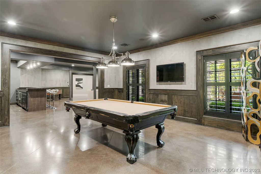 2411 E 34th Street Home in Tulsa, Oklahoma. Experience the epitome of luxury in this one-of-a-kind, majestic midtown mansion. Built in 2010, this stunning residence showcases high ceilings and bright, open rooms that overlook an incredible backyard oasis. Ideal for entertaining, the home features multiple game rooms, a theater, two gyms, a billiards room, and a cigar lounge with ventilation to the outside. Indulge in the 1,000-bottle wine room, relax by the spacious pool and spa, and enjoy outdoor dining with the convenient outdoor kitchen and covered living area.
